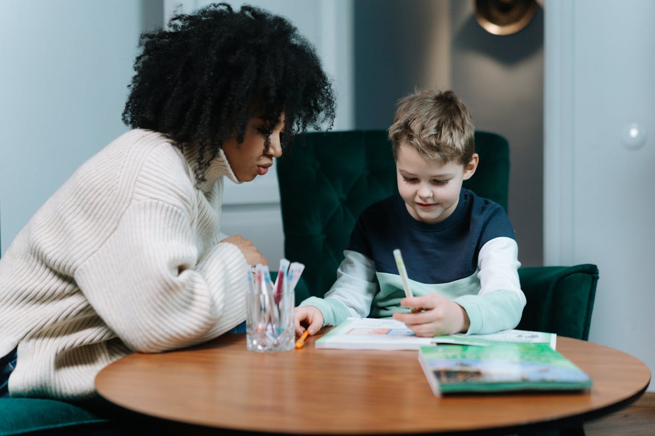 A child and tutor engaged in an educational activity at a cozy indoor setting.